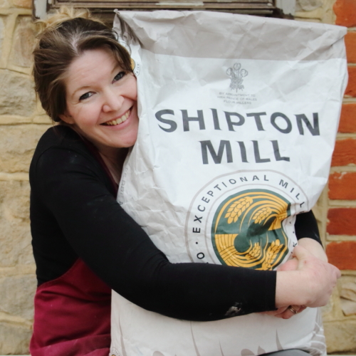 Baker hugging sack of flour - lovingly baked by anthea